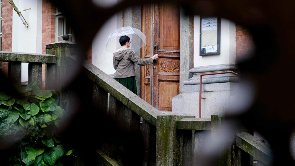 Nainen avaa ulko-oven